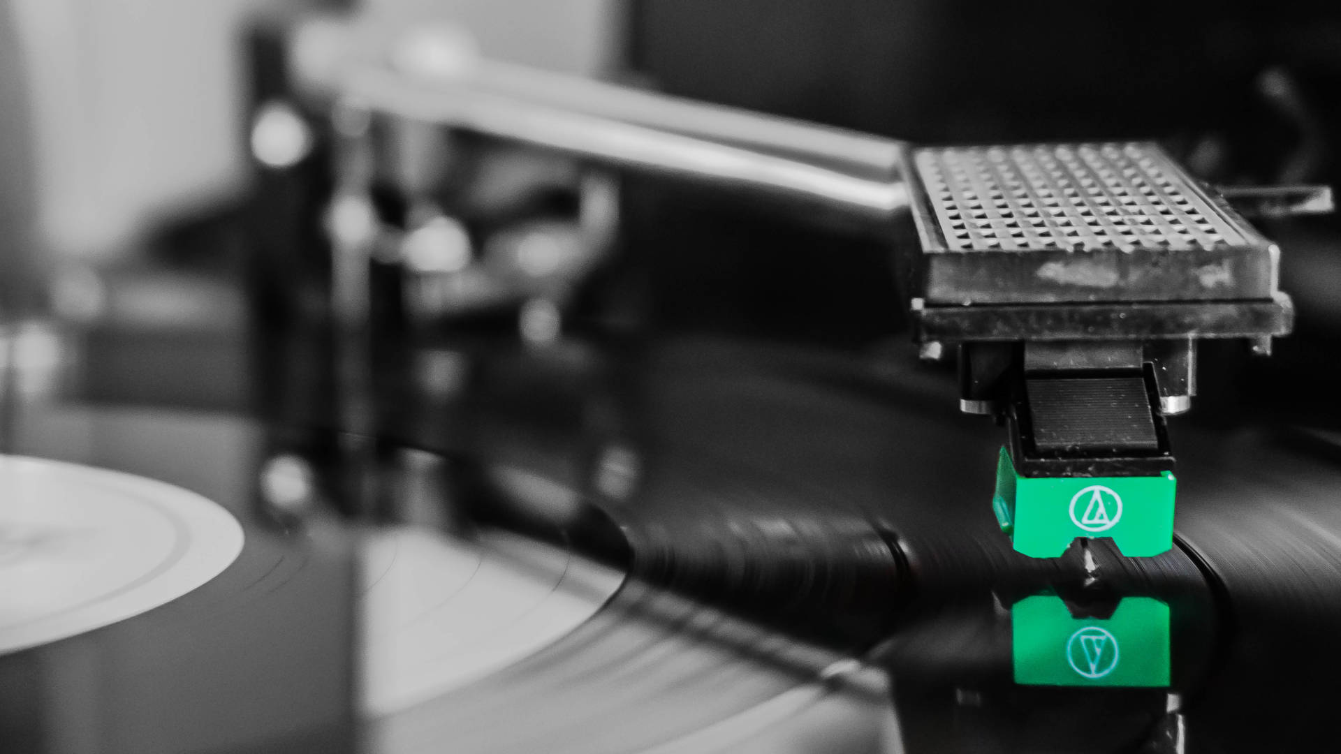 Close-up foto van naald op de plaat. Zwart-wit foto met alleen groen deel van cartridge van de naald